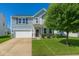 Charming two-story home featuring a manicured lawn, classic curb appeal, and an attached two-car garage at 2006 Creek Bank Dr, Columbus, IN 47201