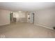 Spacious living room with neutral carpet, paint, and natural lighting, with stairs in the background at 2006 Creek Bank Dr, Columbus, IN 47201