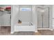 Bright bathroom featuring a soaking tub beneath a window and a separate glass-enclosed shower at 2261 Shadow Trace Way, Greenwood, IN 46143