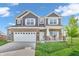 Charming two-story home featuring a brick facade, white trim, covered porch and attached two car garage at 2261 Shadow Trace Way, Greenwood, IN 46143