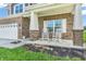 Charming brick home featuring a welcoming front porch with classic rocking chairs at 2261 Shadow Trace Way, Greenwood, IN 46143