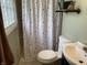 Functional bathroom with a patterned shower curtain, neutral finishes, and simple vanity at 247 N 150 W, Greenfield, IN 46140