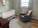 Charming Bedroom featuring hardwood floors, a crib, and a comfortable rocking chair at 247 N 150 W, Greenfield, IN 46140