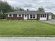 Charming brick ranch home featuring white trim, a well-manicured lawn, and an attached garage at 247 N 150 W, Greenfield, IN 46140