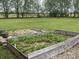 A raised garden bed filled with strawberry plants, with a large backyard and trees in the background at 247 N 150 W, Greenfield, IN 46140