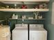 Interior laundry room featuring white washer and dryer, shelving, and painted green walls at 247 N 150 W, Greenfield, IN 46140