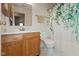 Well-lit bathroom featuring wood vanity, neutral wall color, and floral-themed shower curtain at 2623 Santaro Ct, Indianapolis, IN 46217