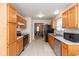Full kitchen view featuring appliances, wood cabinetry, and view to the living room at 2623 Santaro Ct, Indianapolis, IN 46217