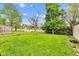 Large grassy backyard with lush green lawn, chain link fence, and sunny skies at 2625 N Boehning St, Indianapolis, IN 46219