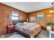 Comfortable bedroom with paneled walls, neutral carpet, gray queen bed and side table at 2625 N Boehning St, Indianapolis, IN 46219