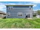 Backyard view of the two-story home featuring a well-maintained lawn, windows, and sliding glass door to a concrete patio at 2972 W Patchwork Dr, Monrovia, IN 46157