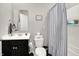 Bathroom features a vanity with sink, toilet, a mirror and a bathtub with a striped shower curtain at 2972 W Patchwork Dr, Monrovia, IN 46157