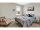 This bedroom features soft gray walls, plush carpet, a cozy chair, and a comfortable bed by the window at 2972 W Patchwork Dr, Monrovia, IN 46157