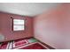 Bright bedroom with a window, pink walls, and unique carpeting, creating a cozy and personalized space at 305 Cardinal Dr, Whiteland, IN 46184