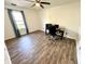 A bright bedroom with wood-look flooring, ceiling fan, and large window at 4223 Kestrel Ct, Indianapolis, IN 46254