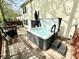Deck area featuring a modern hot tub, adjacent to a home with light yellow siding and green shutters at 4223 Kestrel Ct, Indianapolis, IN 46254