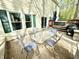 Outdoor patio with dining table and chairs, leading to a deck with a hot tub and lush backyard at 4223 Kestrel Ct, Indianapolis, IN 46254