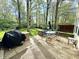 Relaxing patio area featuring a grill, stone flooring, outdoor seating, and a view of the lush backyard at 4223 Kestrel Ct, Indianapolis, IN 46254