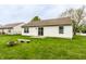 Private fenced backyard with green lawn, fire pit, concrete benches, and sliding glass door at 4303 Cowslip Ct, Indianapolis, IN 46203