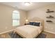Comfortable bedroom features a decorative window, neutral color scheme, and stylish floating shelves at 4303 Cowslip Ct, Indianapolis, IN 46203