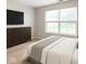This bedroom has a large window for natural light, a modern dresser, and neutral decor at 4303 Cowslip Ct, Indianapolis, IN 46203
