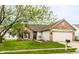 Inviting home with brick and siding exterior, attached garage, and green lawn with mature tree at 4303 Cowslip Ct, Indianapolis, IN 46203