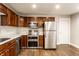 Contemporary kitchen featuring stainless steel appliances, dark wood cabinets, and ample counter space at 4303 Cowslip Ct, Indianapolis, IN 46203