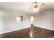 Bright living room with hardwood floors, fan, and a serving hatch to a kitchen at 4303 Cowslip Ct, Indianapolis, IN 46203