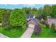 Aerial view of home surrounded by mature trees, lush landscaping, and well-maintained lawn at 4401 W Hunters Ridge W Ln, Greenwood, IN 46143