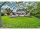 Green lawn leads to brick retaining wall, showcasing inground pool and back of a two-story home at 4401 W Hunters Ridge W Ln, Greenwood, IN 46143