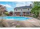 Two-story home backyard showcasing a large pool, manicured lawn, and lounge furniture at 4401 W Hunters Ridge W Ln, Greenwood, IN 46143