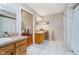 En-suite bathroom with double sinks, white tile, and entry to main bedroom at 4401 W Hunters Ridge W Ln, Greenwood, IN 46143