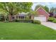 Charming home featuring a manicured lawn, mature trees, and a classic brick facade with a two car garage at 4401 W Hunters Ridge W Ln, Greenwood, IN 46143