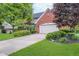 Traditional brick home featuring lush landscaping, a well-manicured lawn, and a spacious driveway at 4401 W Hunters Ridge W Ln, Greenwood, IN 46143