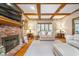 Comfortable living room with a brick fireplace, wood-beamed ceiling, and lots of natural light at 4401 W Hunters Ridge W Ln, Greenwood, IN 46143