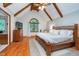 Vaulted main bedroom with wooden beams, arch window, and ensuite bathroom at 4401 W Hunters Ridge W Ln, Greenwood, IN 46143