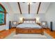Spacious main bedroom showcasing wood beams, hardwood floors and large window at 4401 W Hunters Ridge W Ln, Greenwood, IN 46143