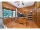 Cozy home office with wood-paneled walls, hardwood floors, and a large window for ample natural light at 4401 W Hunters Ridge W Ln, Greenwood, IN 46143