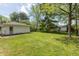 A spacious backyard featuring a lush lawn, mature trees, and a detached garage at 4468 N Elizabeth St, Indianapolis, IN 46226