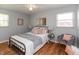 Inviting bedroom with natural light, hardwood floors, ceiling fan, decorative pillows, and a cozy chair at 4468 N Elizabeth St, Indianapolis, IN 46226