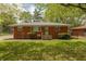 Charming brick home featuring a well-maintained lawn and mature trees under a sunny blue sky at 4468 N Elizabeth St, Indianapolis, IN 46226