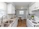 Well-lit kitchen featuring granite counters, white cabinetry, and modern appliances with dining area access at 4468 N Elizabeth St, Indianapolis, IN 46226