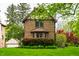Classic brick home featuring a well-manicured lawn, mature shrubs, and lovely architectural details at 5124 N Capitol Ave, Indianapolis, IN 46208