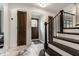Elegant foyer featuring marble floors, wood staircase with iron railing and natural light at 5124 N Capitol Ave, Indianapolis, IN 46208