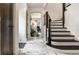 Bright foyer with marble floors, staircase with wood banister, and arched doorway with transom window at 5124 N Capitol Ave, Indianapolis, IN 46208