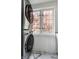 Bright laundry room featuring a stacked washer and dryer next to a window at 5124 N Capitol Ave, Indianapolis, IN 46208