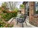 Charming patio seating area with a table and chairs, surrounded by lush greenery and a brick building at 5124 N Capitol Ave, Indianapolis, IN 46208