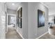 Neutral hallway featuring decorative paintings and a view into another room at 5163 Nettleton Way, Avon, IN 46123
