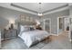 This spacious main bedroom features an elegant light fixture, neutral decor, and plush carpeting for a comfortable feel at 5163 Nettleton Way, Avon, IN 46123