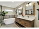 Stylish bathroom with a modern tub, double sink vanity, wooden cabinetry, and elegant lighting at 5255 Apache Moon, Carmel, IN 46033